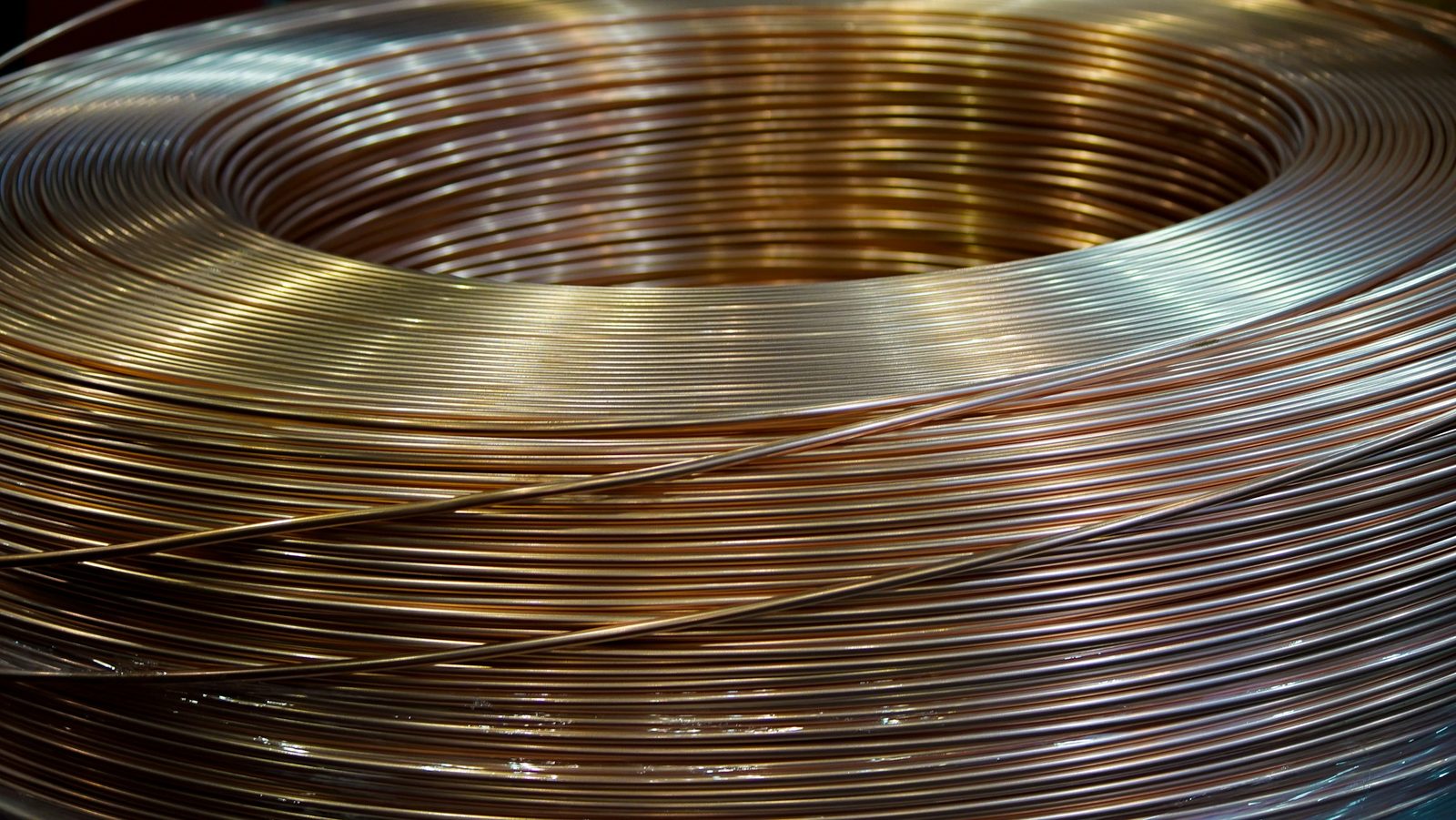 A coil of wire with copper and steel tones in the same turn